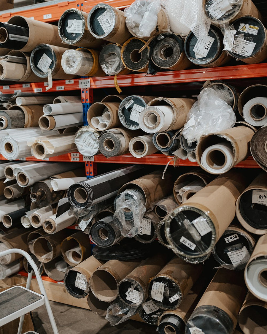 Racks of blind fabric rolls in the Novo Blinds Edmonton factory