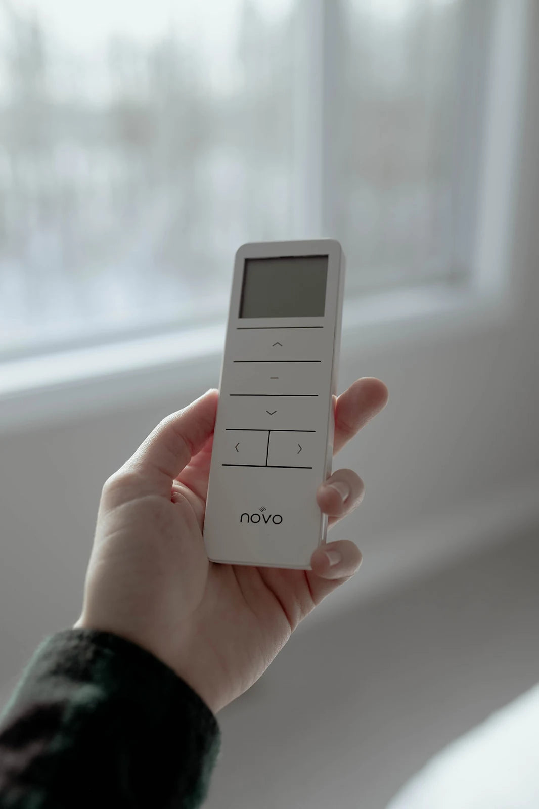 A Novo remote held in hand